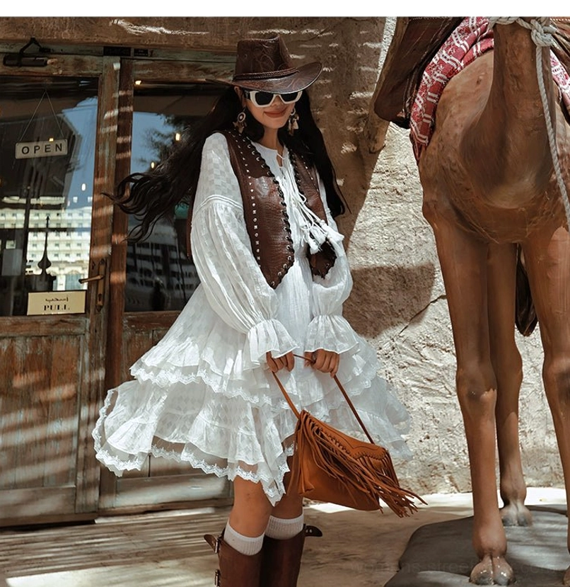 White western ruffle midi dress with brown leather vest fringe tote bag cowboy hat and brown buckle knee high boots