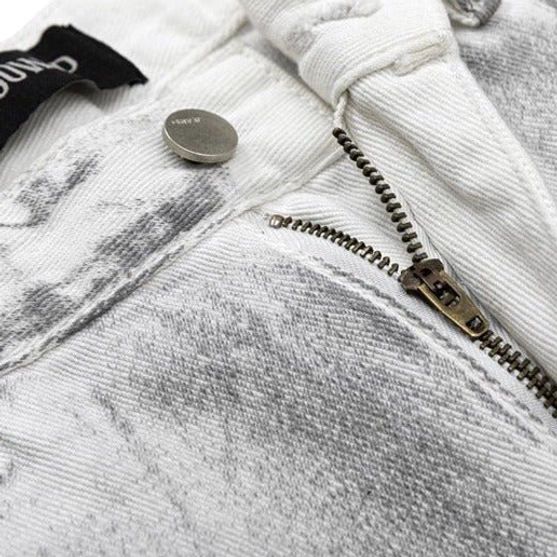 Close-up of white wide leg jeans waistband, metal button fly, fabric tag, and thick gray washed cotton denim texture