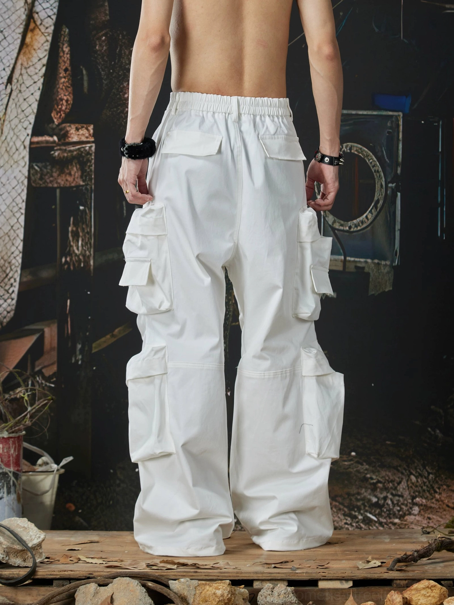 White wide-leg utility cargo pants rear view showing elastic back waistband, multiple pockets, and baggy streetwear cut