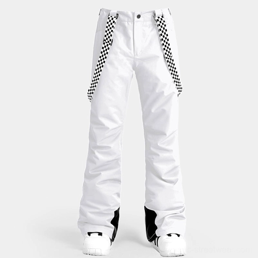Front view of white women's ski pants with checkerboard decorative suspenders, flared snow pant silhouette, black ankle trim, and winter shoes
