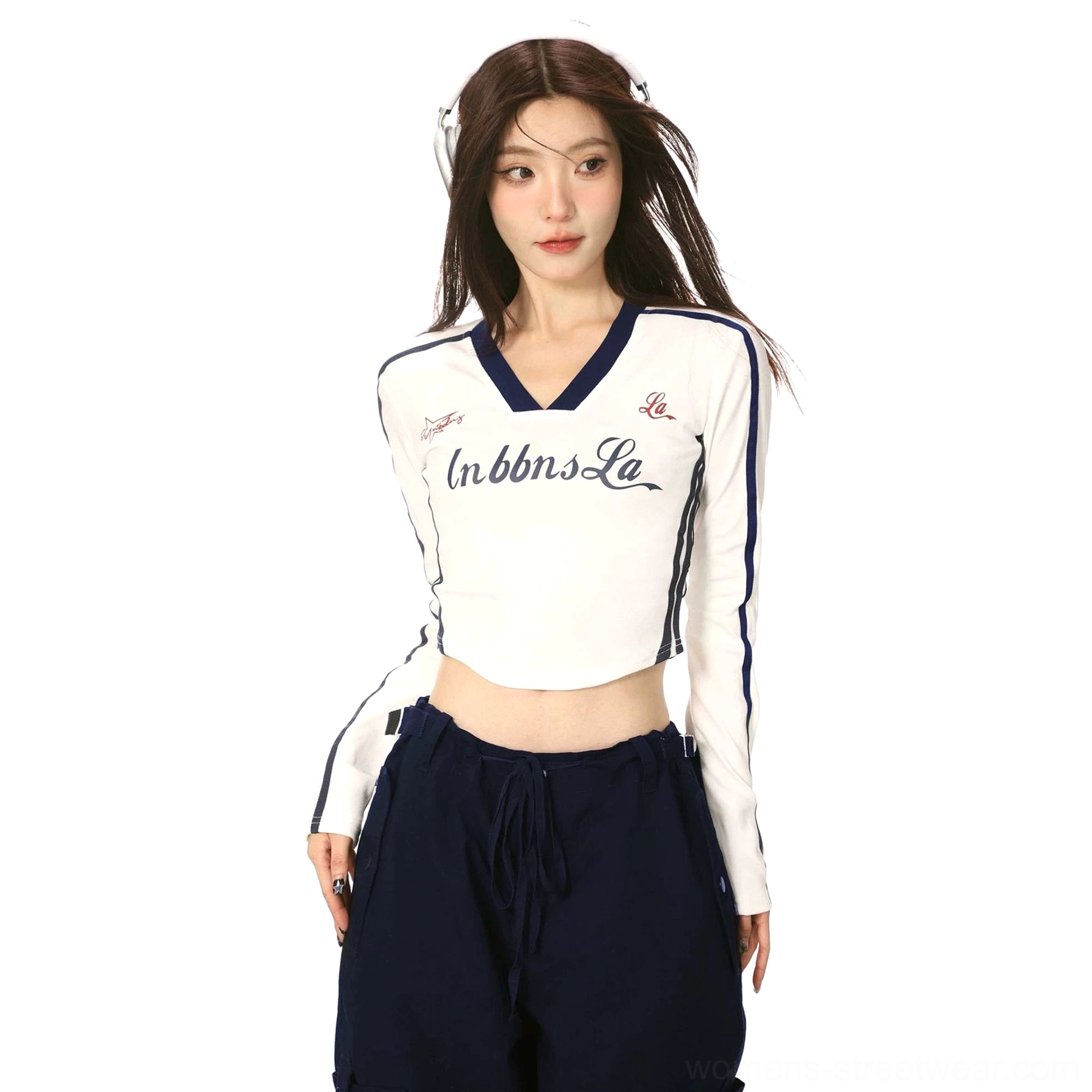 Close-up of a white women's cropped sporty long sleeve top with navy trim, InbbnsLa chest print, V-neckline, and curved hem