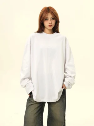 White oversized long sleeve t-shirt for women styled with wide leg denim, relaxed drop shoulder sleeves, and minimalist Seoul streetwear proportions
