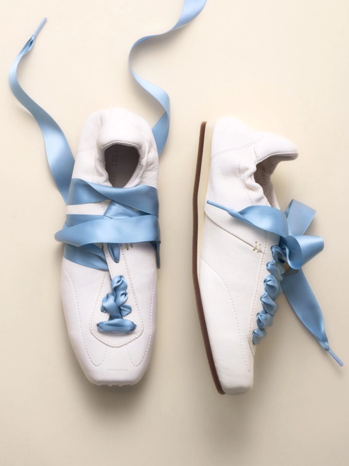 Pair of white women's ribbon lace retro trainers showing the front and side profile with blue satin laces