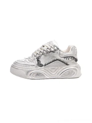 White Wukong-inspired sculpted platform sneakers with bone relief panels, distressed off-white upper, chunky wave-molded sole, and curled laces shown in side view