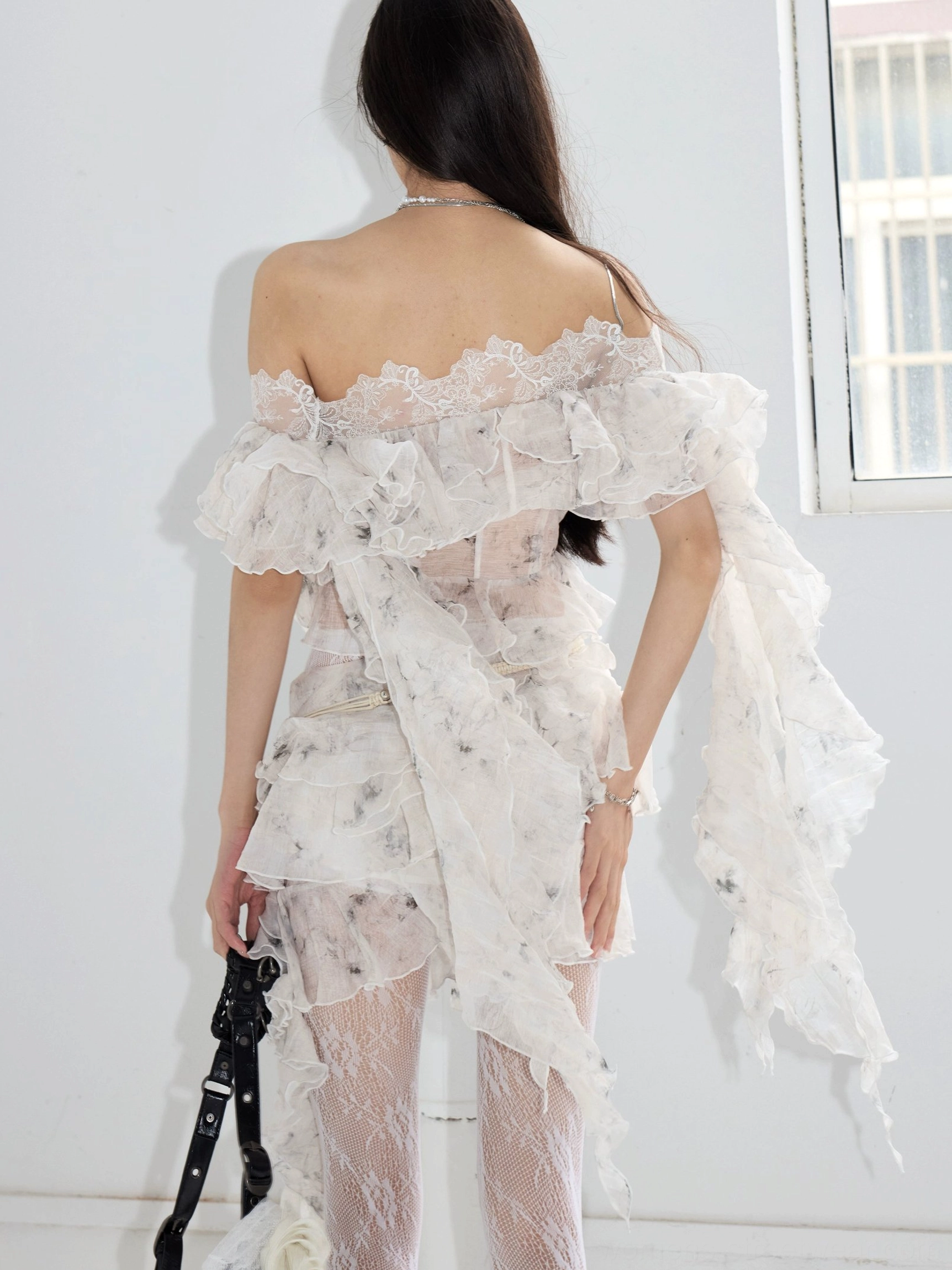 White Y2K-inspired off-shoulder lace ruffle outfit with cropped styling, layered drape and statement streetwear silhouette