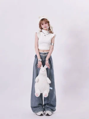 Women’s white ruffle sleeve mock neck crop top with bow pin styled in a Korean Y2K streetwear outfit with wide leg jeans