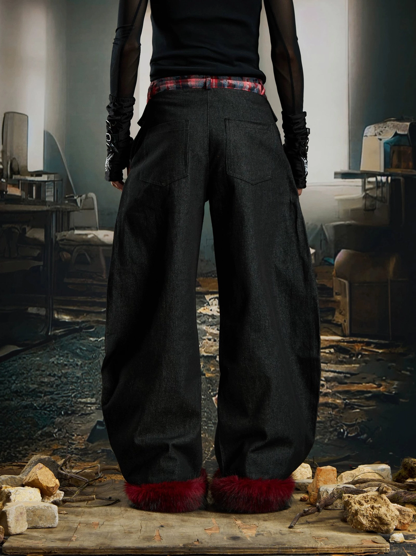 Back view of wide-leg black streetwear cargo pants with red tartan waistband dark red faux-fur cuffs and cargo pockets