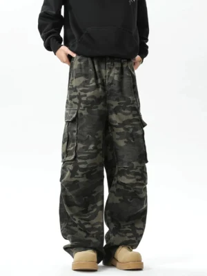 Front view of relaxed wide-leg camouflage streetwear cargo pants showing the elastic waistband, hidden drawstring, side pockets, and oversized utility silhouette