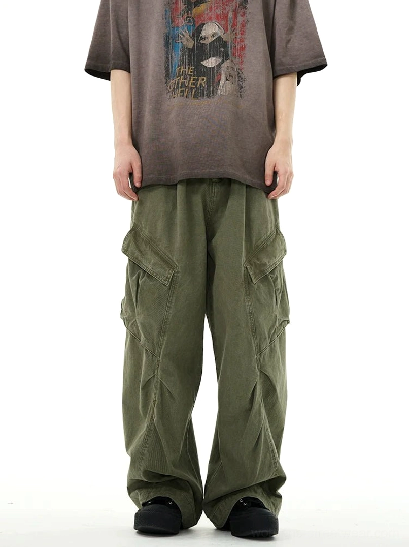 Army green inspired wide-leg cargo workwear pants styled with a vintage graphic tee, showing the loose straight-leg cut, front pleats, and dual side pockets