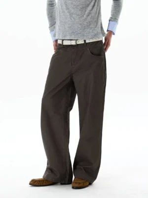 Side view of dark brown wide-leg chino streetwear pants styled with a white leather belt and brown loafers