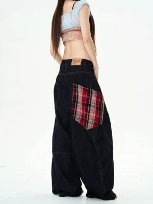 Back view of wide-leg denim cargo pants featuring a red plaid back pocket, leather waistband tag, and relaxed streetwear fit