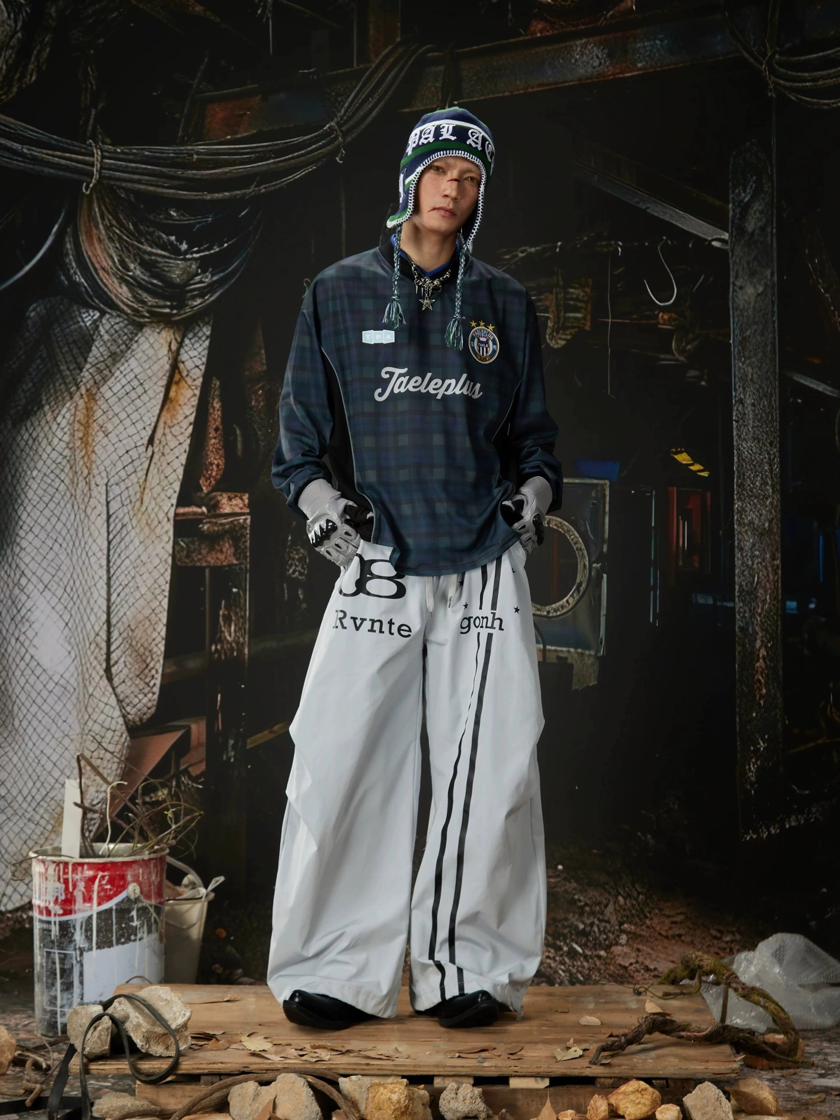 Wide-leg streetwear track pants featuring an elastic drawstring waist, relaxed fit, varsity-inspired graphics, and utility styling
