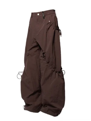 Dark brown wide leg technical cargo pants with drawstring waist cargo pockets and adjustable ankle cuffs shown from the front three quarter view