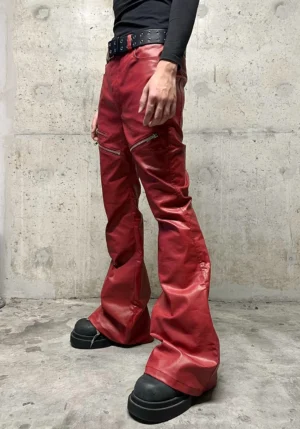 Model wearing wine red coated flare jeans with black long sleeve top studded belt and chunky platform boots