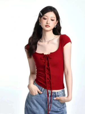 Wine red lace-up square neck fitted ribbed short sleeve streetwear T-shirt styled with blue denim jeans and silver accessories