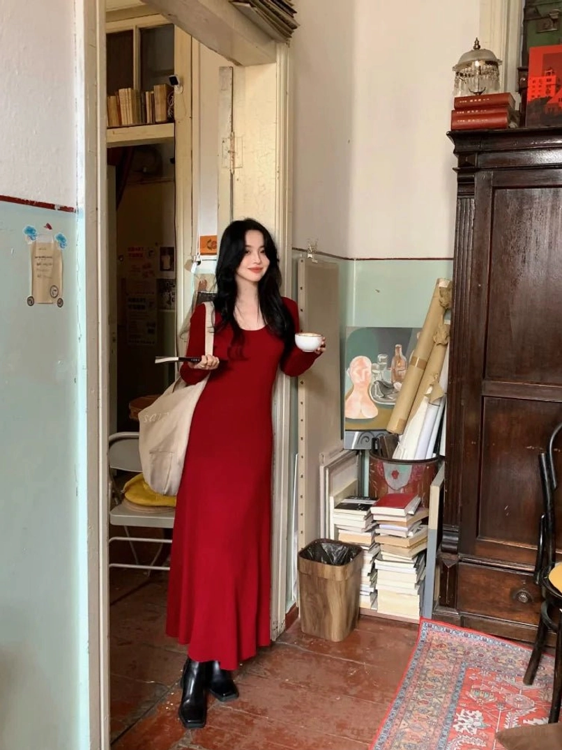Wine red long sleeve scoop neck bodycon knit maxi dress in a full front view at a vintage bookstore entrance