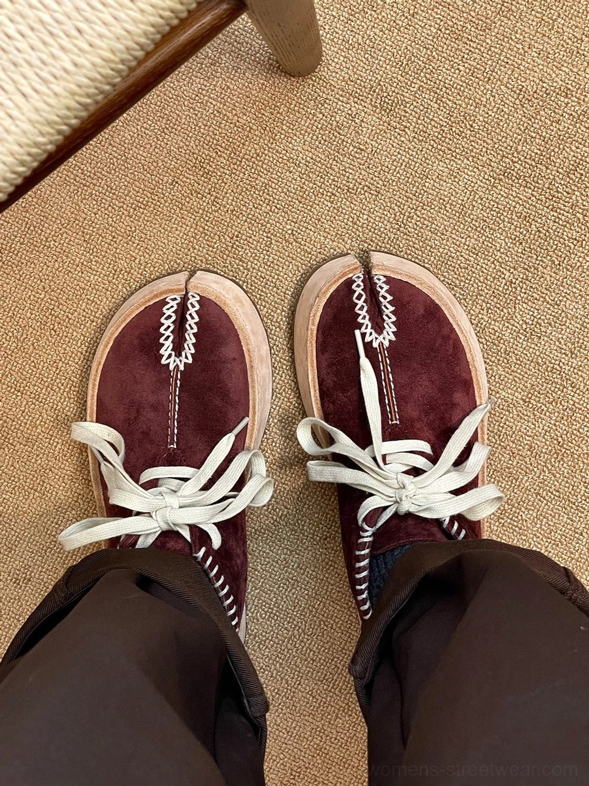 Wine red split-toe leather chukka boots worn with dark brown trousers in a casual top-down streetwear view