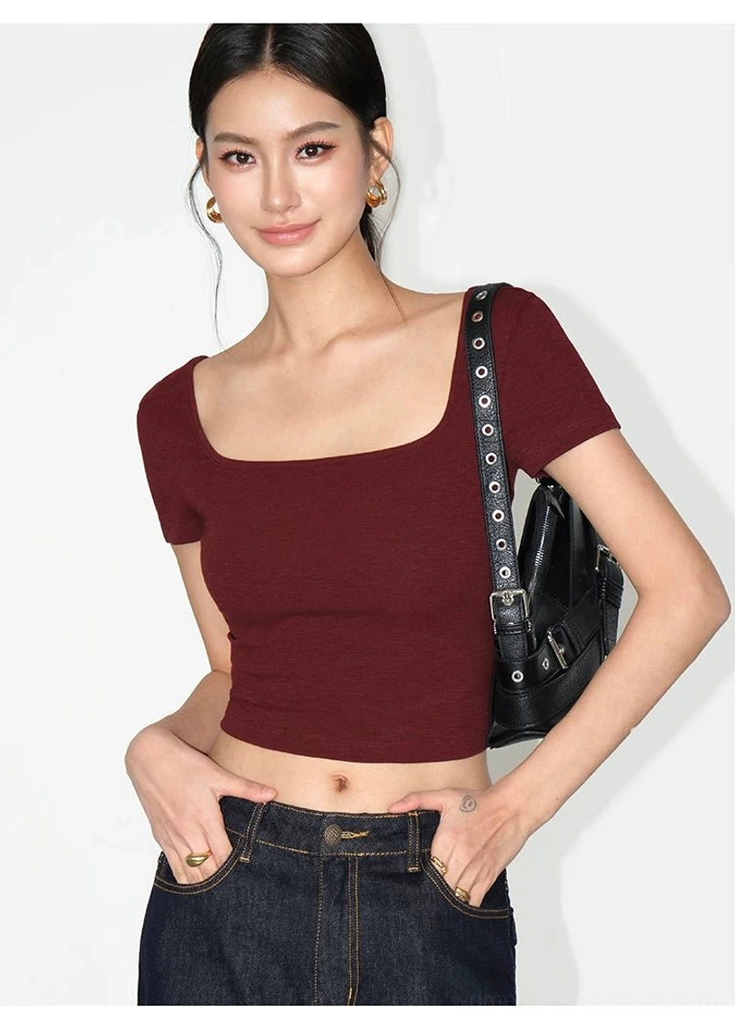 Wine red women's fitted square neck crop tee with dark denim jeans and a black shoulder bag strap