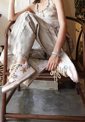 Woman wearing beige and brown retro star court sneakers with neutral linen streetwear outfit in a vintage interior