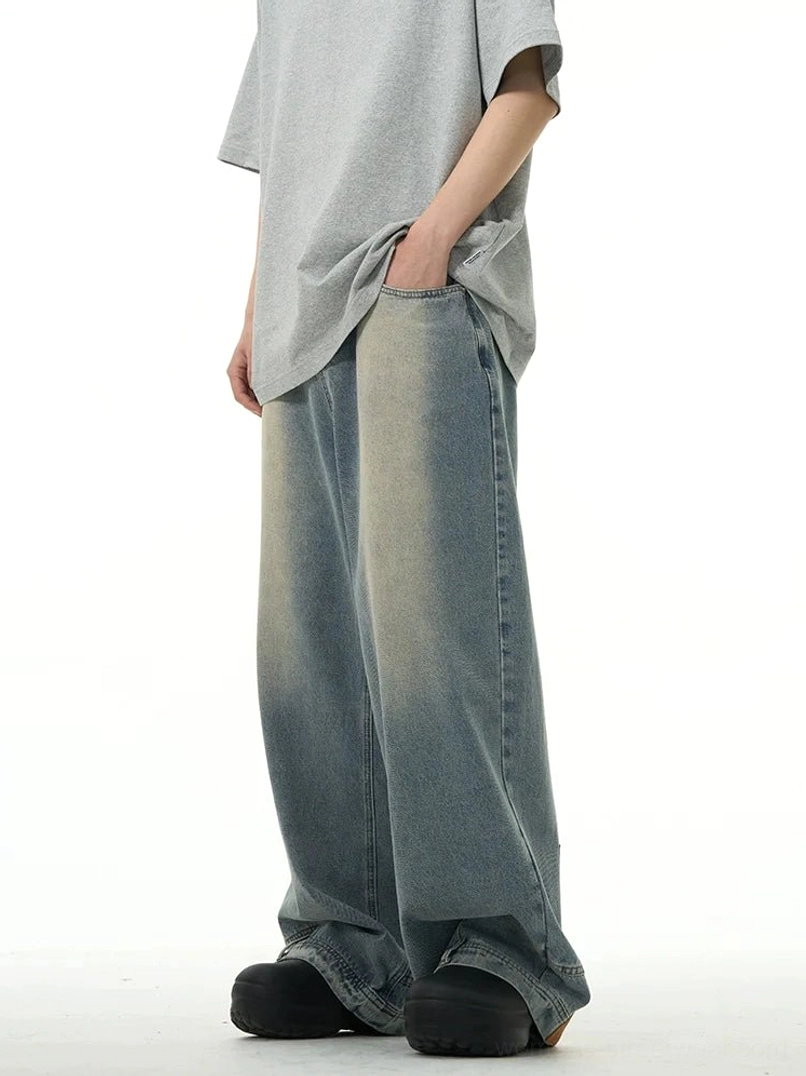 Side view of women’s light blue inside-out wide-leg denim jeans showing loose profile, front pocket, faded panels, and oversized streetwear styling