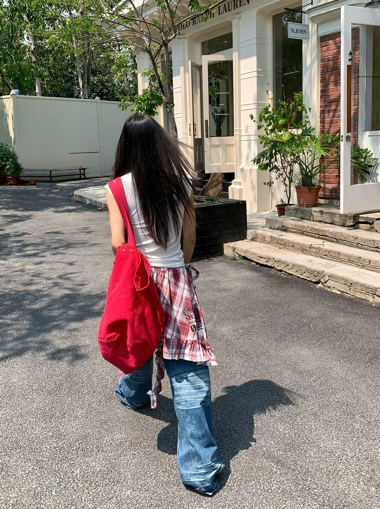 Rear view of women low-rise wide-leg denim jeans showing the relaxed silhouette and plaid shirt waist layer