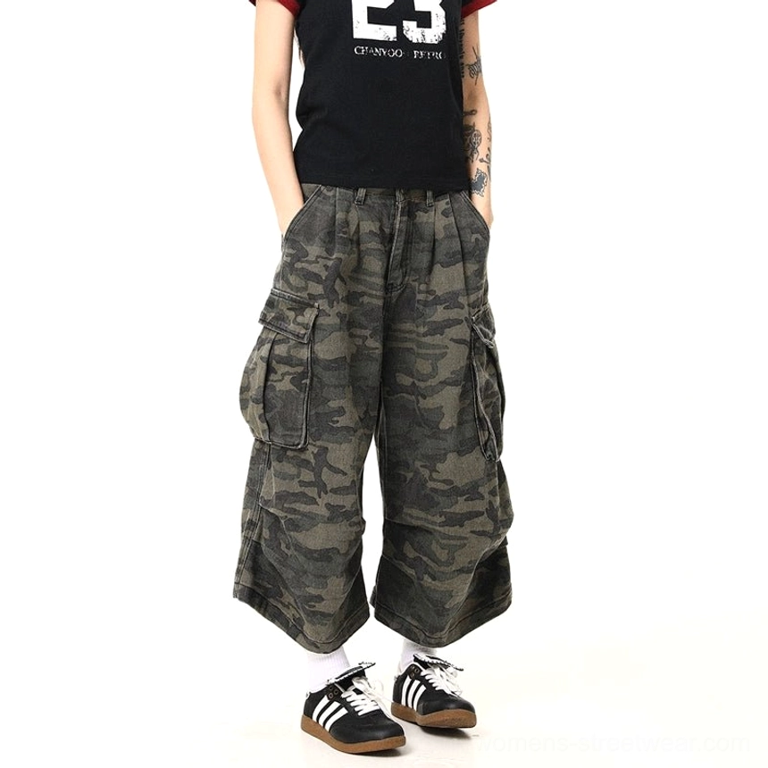 Front view of women’s washed military green camouflage cargo pants with oversized side pockets, pleated high waist, relaxed wide-leg streetwear fit, and utility-inspired styling
