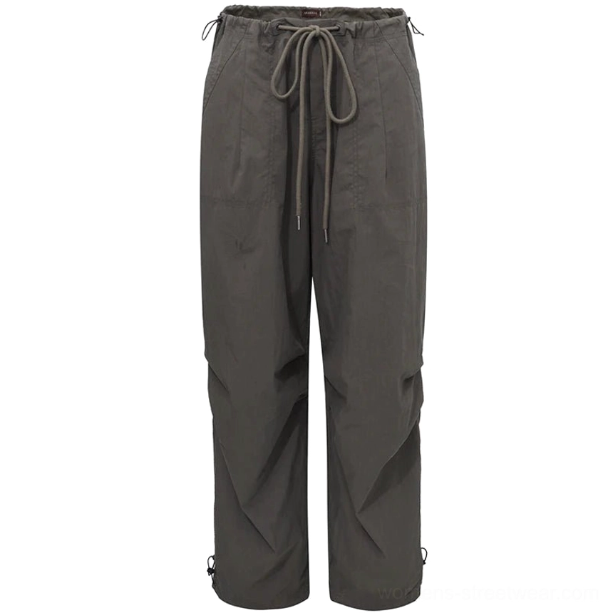 Close-up flat lay of charcoal gray women's parachute cargo pants with long waist drawstrings and adjustable gathered ankle cuffs