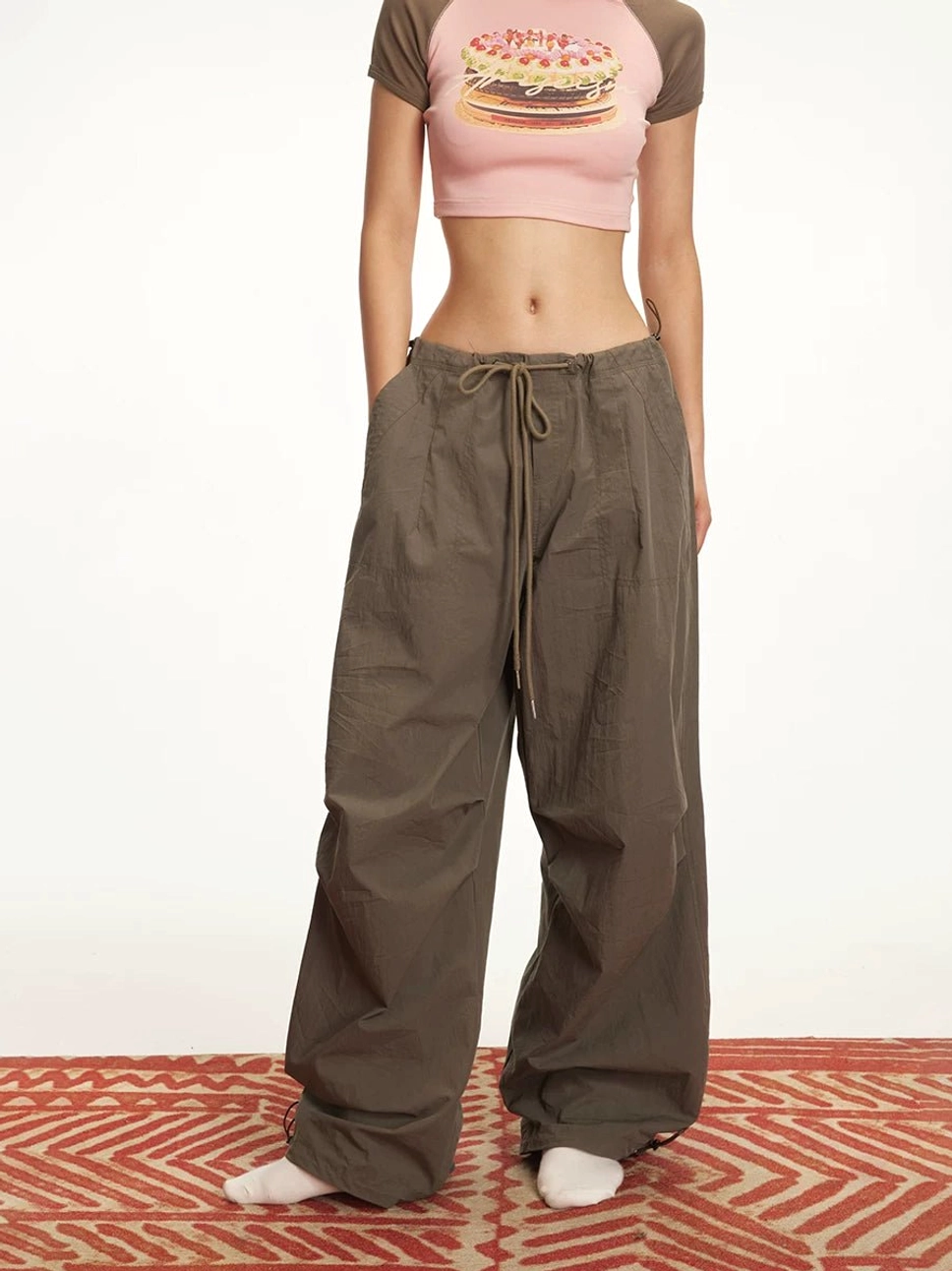 Front view of women's dark brown relaxed wide-leg parachute cargo pants with drawstring waist and gathered ankles