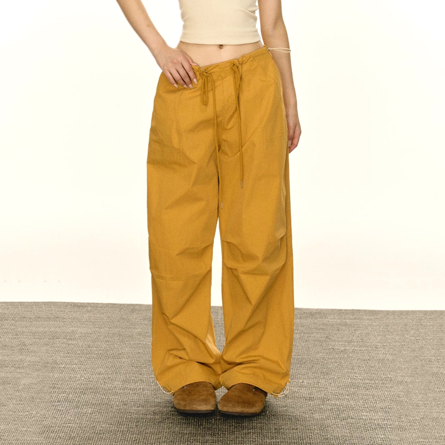 Women's adjustable hem parachute cargo pants in yellow colorway with relaxed wide-leg streetwear silhouette