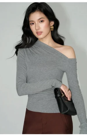 Heather gray asymmetric one-shoulder ruched knit top styled with brown midi skirt in studio