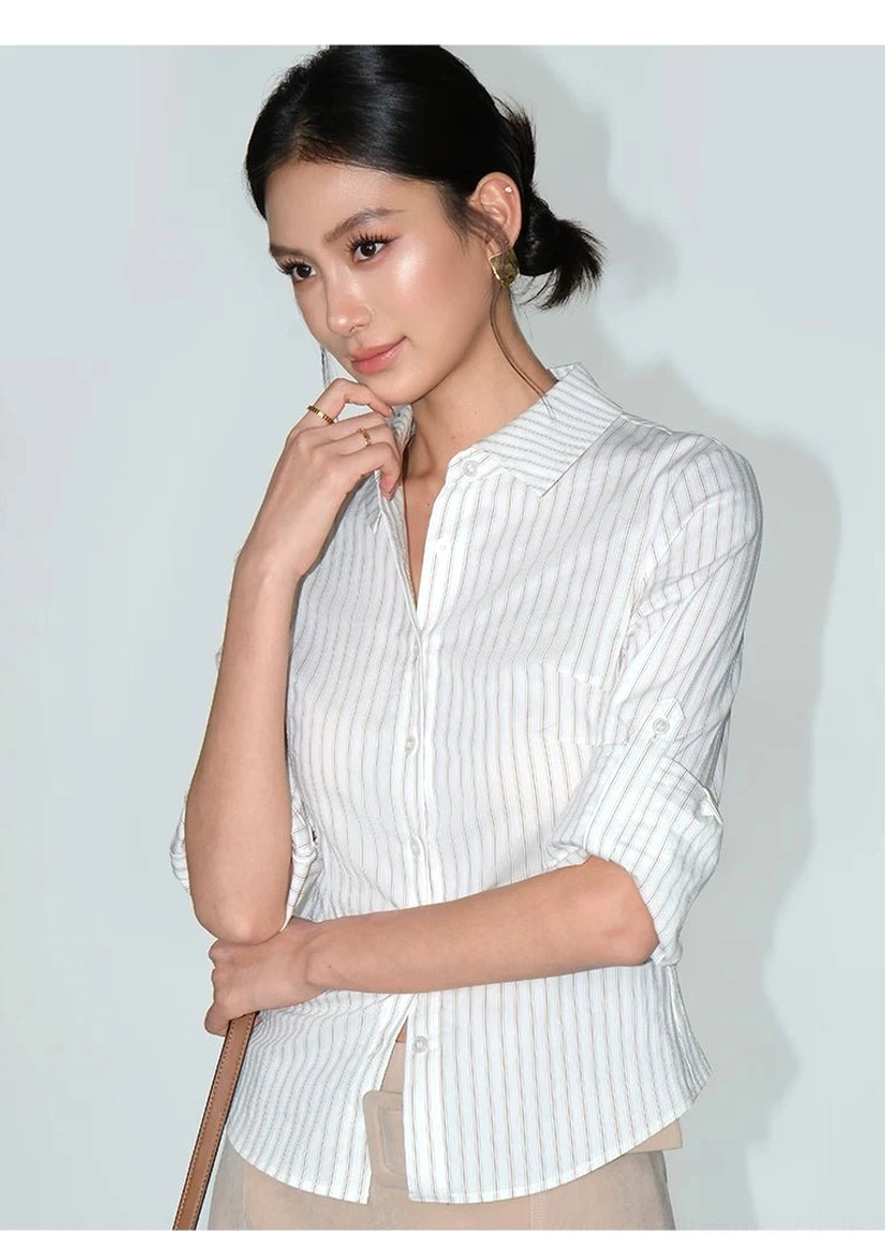 Close front styling view of a women's asymmetrical rolled-sleeve striped shirt with slim tailored fit and shoulder strap