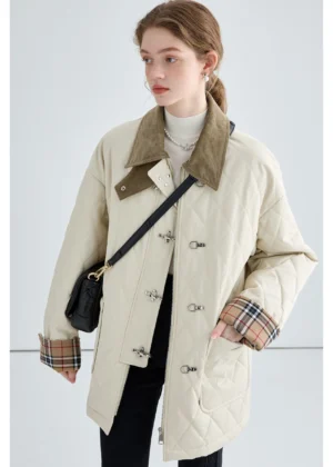 Women's beige quilted cotton jacket with brown corduroy collar, plaid cuffs and metal buckle closures styled in a city streetwear outfit