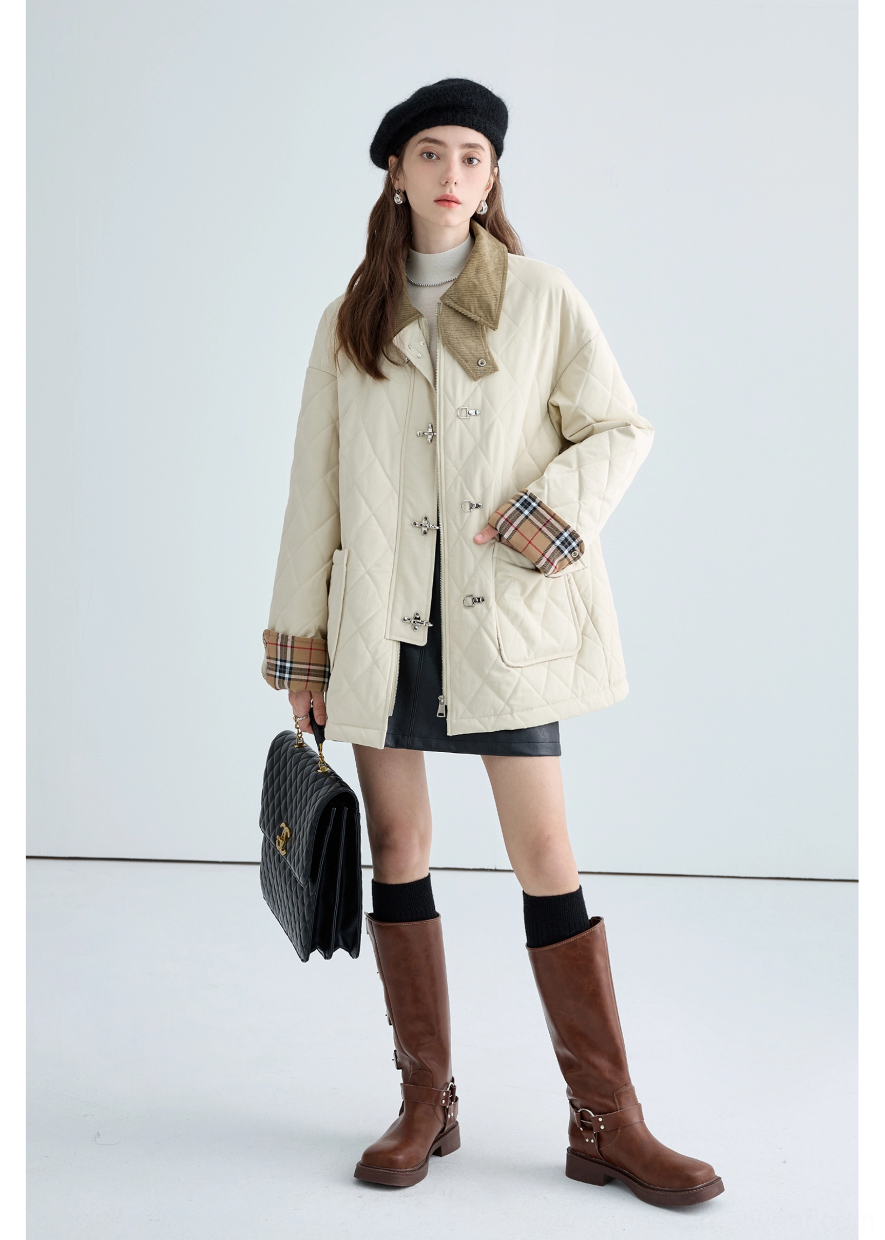 Side view of women's contrast collar quilted cotton jacket in beige with plaid sleeve cuffs and metal front hardware