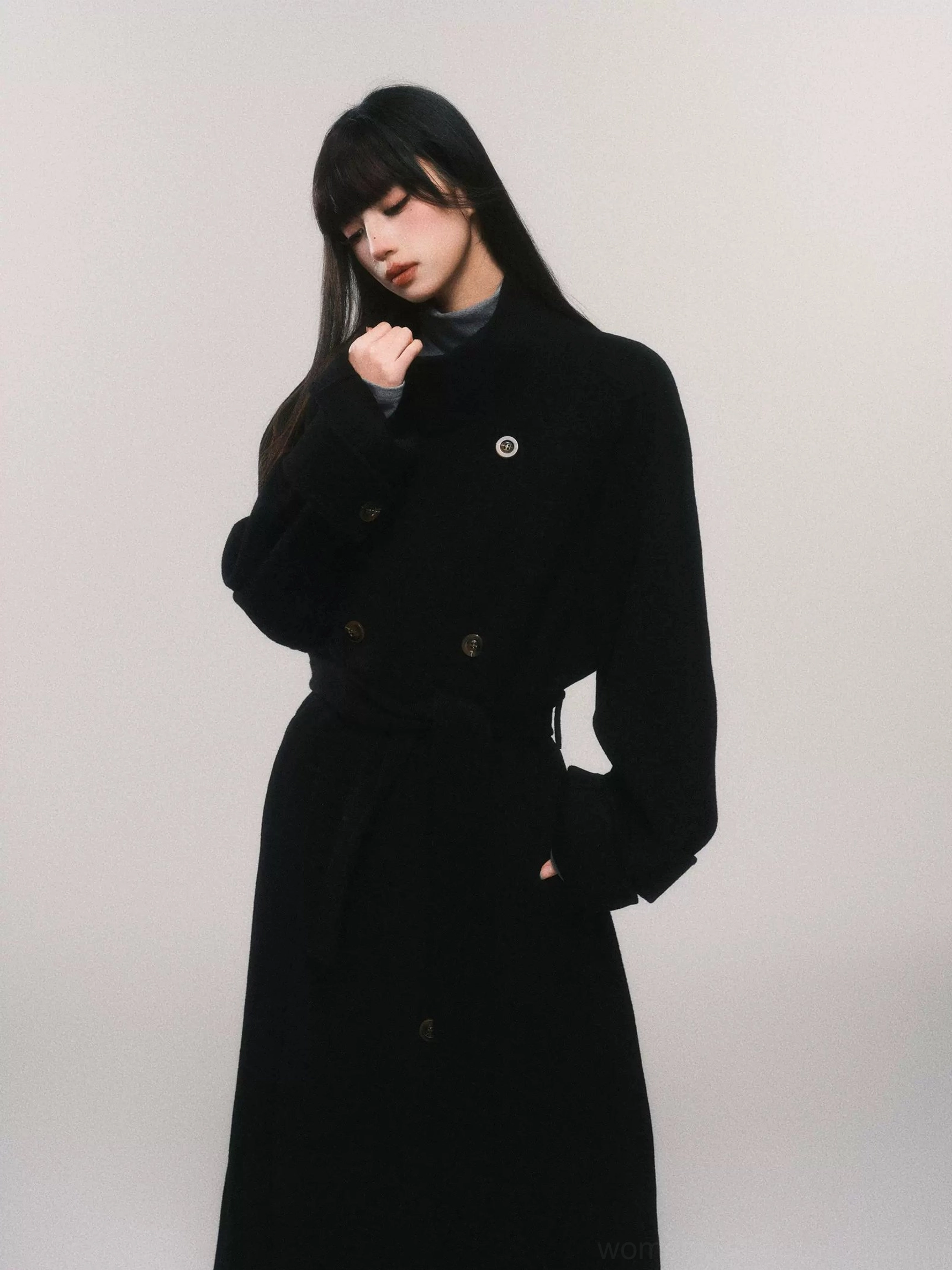 Women's black belted double-breasted wool maxi trench coat side profile showing long tailored silhouette