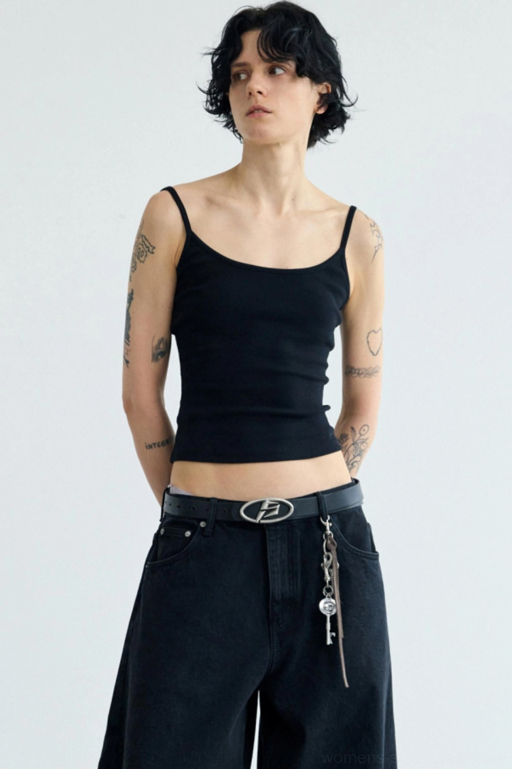 Women's black cropped camisole streetwear tank top with round neckline styled with wide-leg black pants side front view