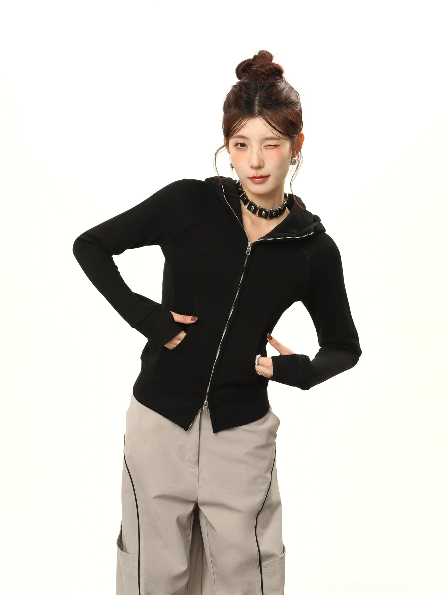 Front half-body view of a women's black double-zip hooded streetwear sweatshirt with fitted silhouette, raglan sleeves, and curved split hem