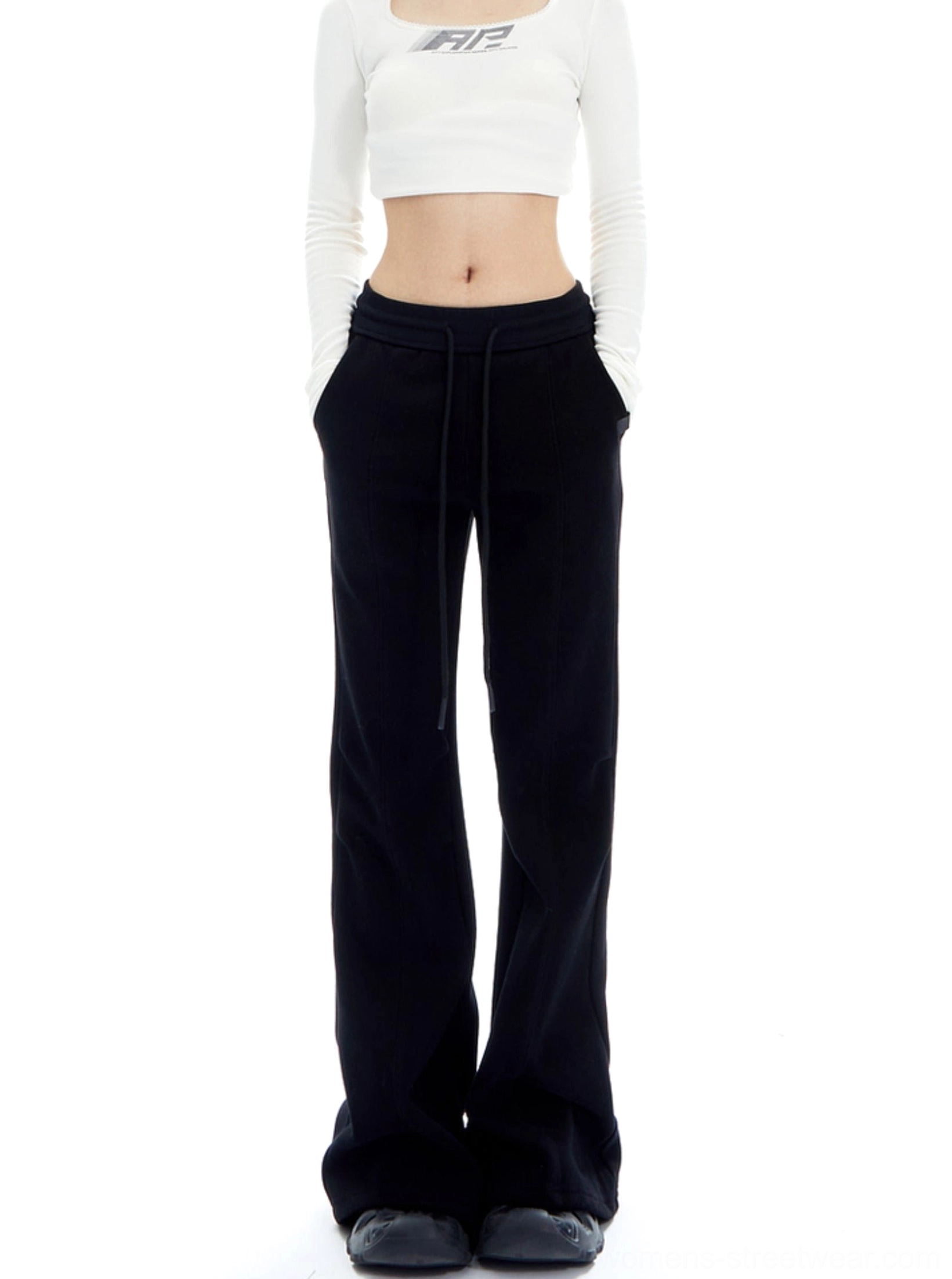 Black high-waisted flared lounge pants with drawstring waist and side pockets styled with a white cropped top