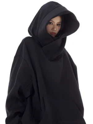 Black women's oversized high-neck hooded pullover with sculptural hood, drop shoulders, kangaroo pocket, and relaxed Y2K streetwear fit