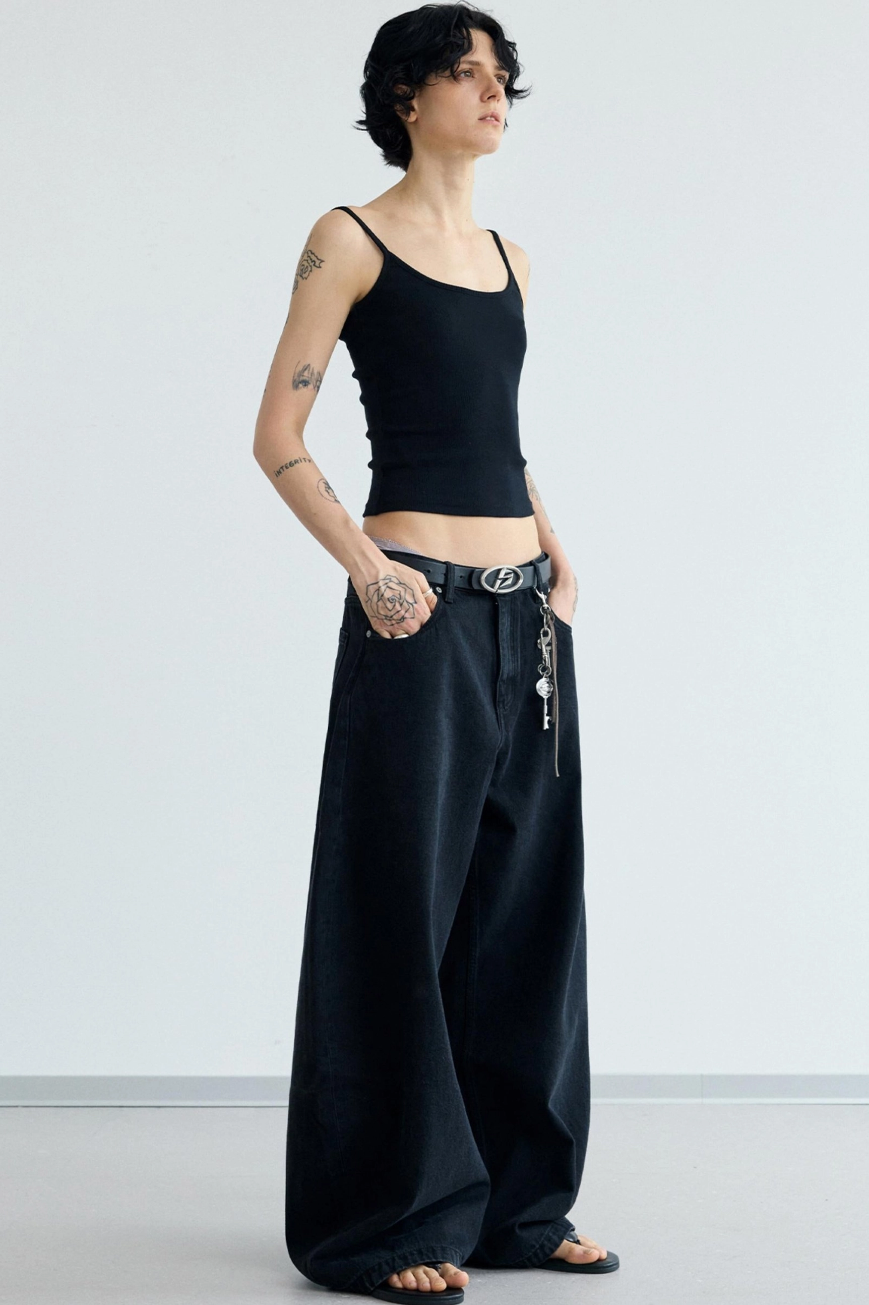 Side view of women's black ribbed-look cropped camisole streetwear top with fitted silhouette