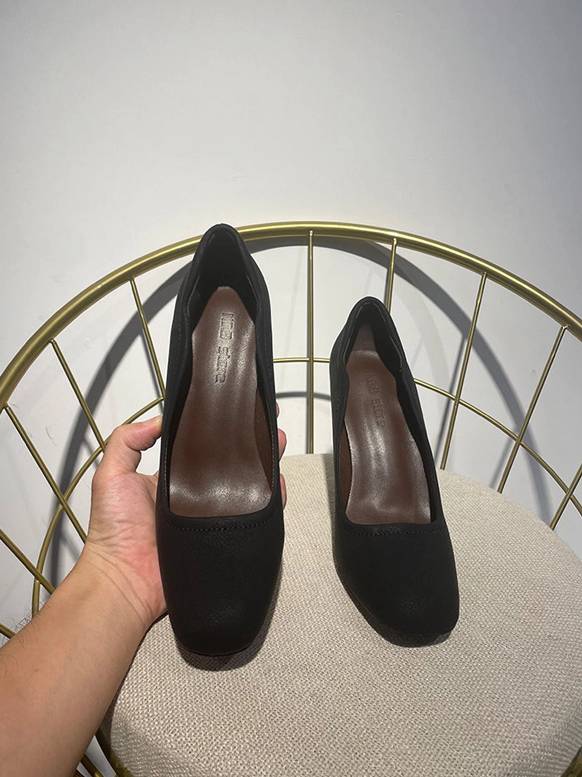 Front view of black sculpted heel round-toe pump showing contrast stitch trim, scalloped topline, and brown insole