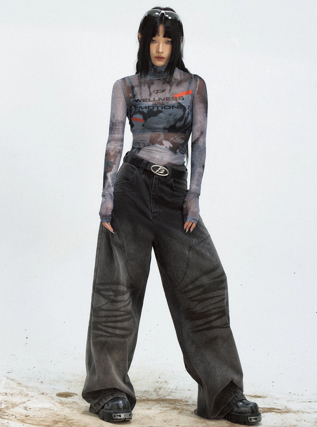 Front view of women's black sheer mesh cropped turtleneck streetwear top with graphic print and wide-leg denim outfit