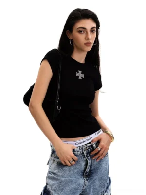 Women's black slim fit cross embroidered baby tee with low rise blue jeans and shoulder bag