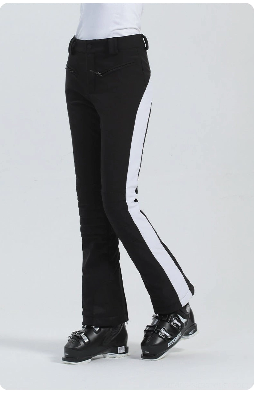Black and white women's flared ski pants showing belt loops, tailored knee shaping, contrast side panel, and bootcut fit