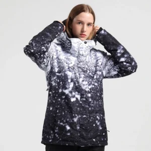 Women’s black and white snowscape printed ski jacket worn by model, featuring a high collar, hood, front snap closure, and winter streetwear silhouette