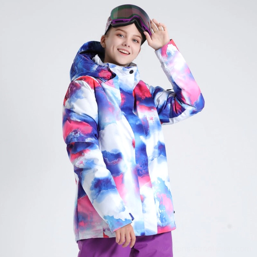 Women’s blue cloud aurora nebula ski shell jacket with blue pink and white gradient print styled with ski goggles and purple snow pants