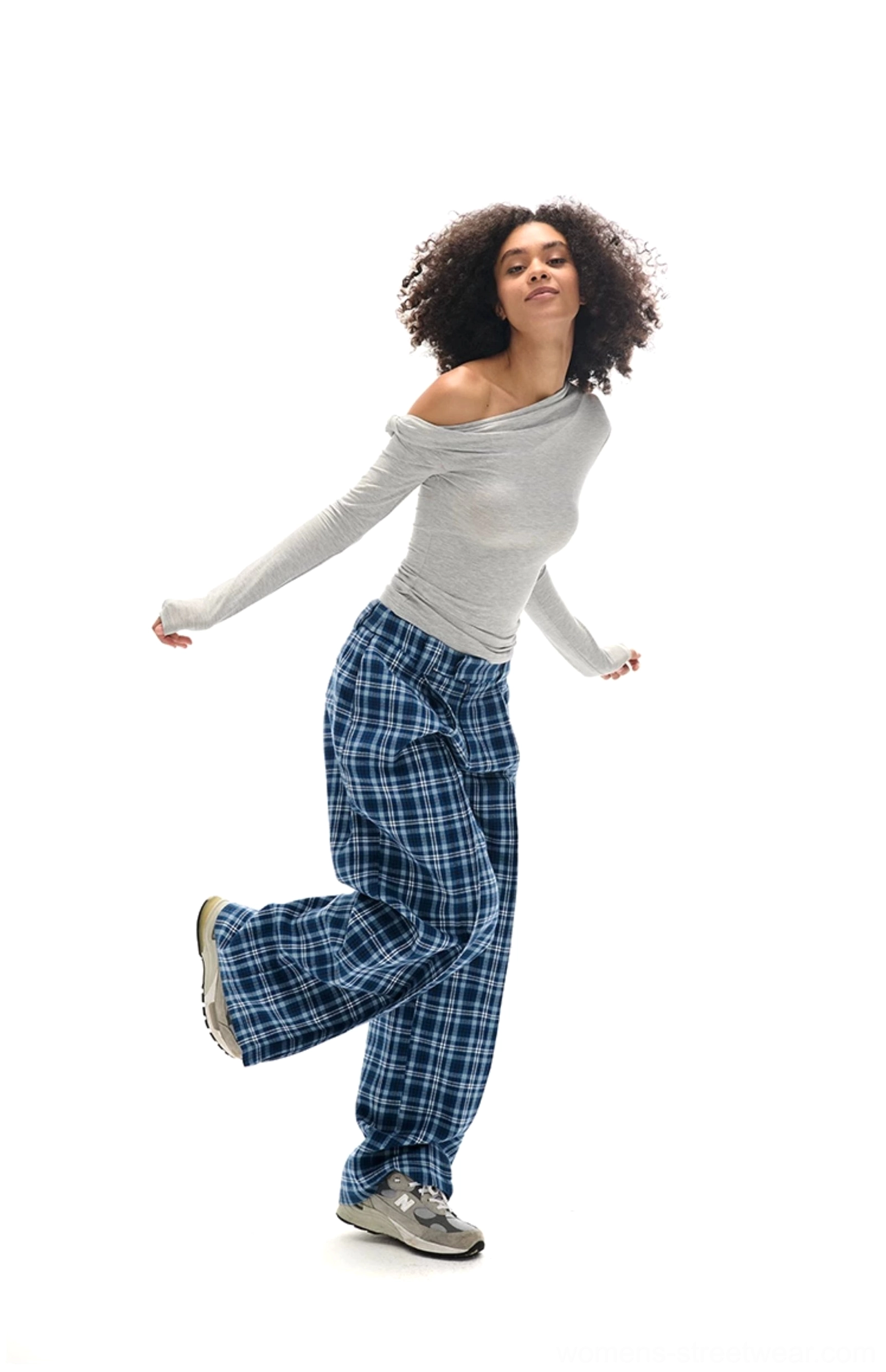 Dynamic side view of women’s blue plaid relaxed wide-leg pants styled with casual sneakers for everyday streetwear