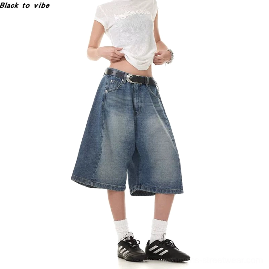 Front view of women's washed blue denim Bermuda shorts with side panel tailoring, faded texture, low-rise fit, and relaxed knee-length wide legs