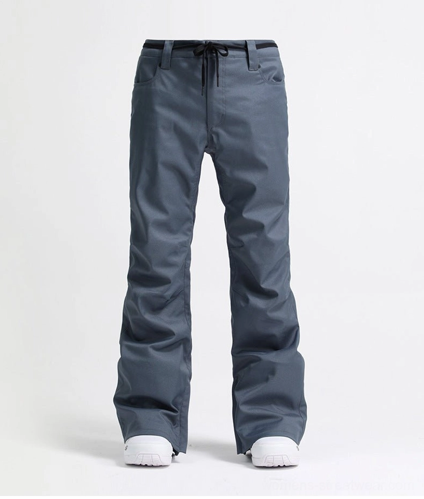 Bluish gray flared women's ski pants shown in a front flat lay with drawstring waist, functional pockets, and white snow boots