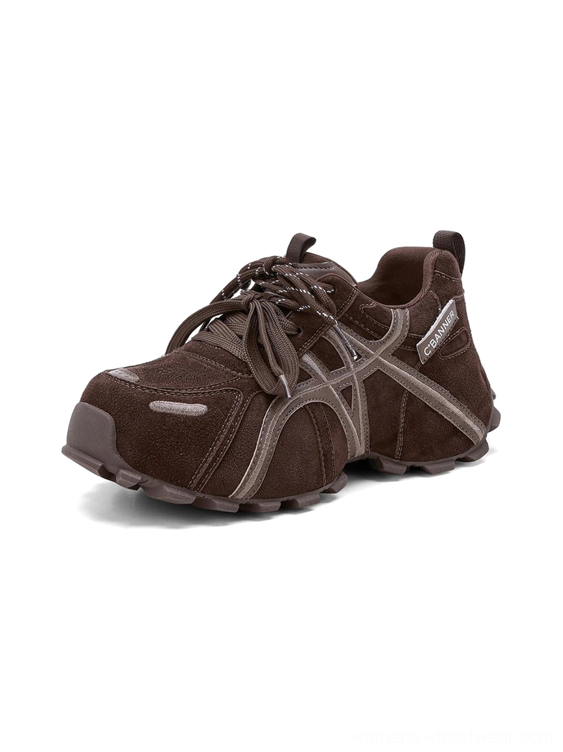 Close-up front three-quarter view of women's brown cross-strap chunky trail runner sneaker with layered toe panel and rugged outsole