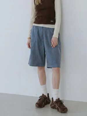 Female model wearing women's brown cross-strap chunky trail runner sneakers with white socks and neutral casual streetwear outfit